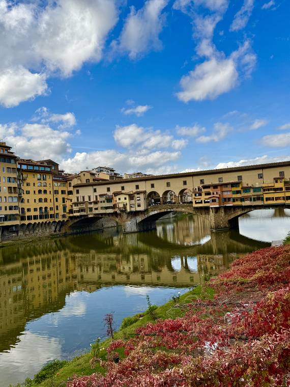 The Ponte Vecchio bridge reflected in the Arno river, Florence, Italy