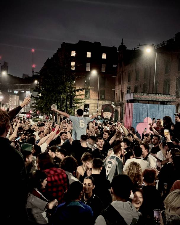 A crowd celebrating at night in Manchester, England