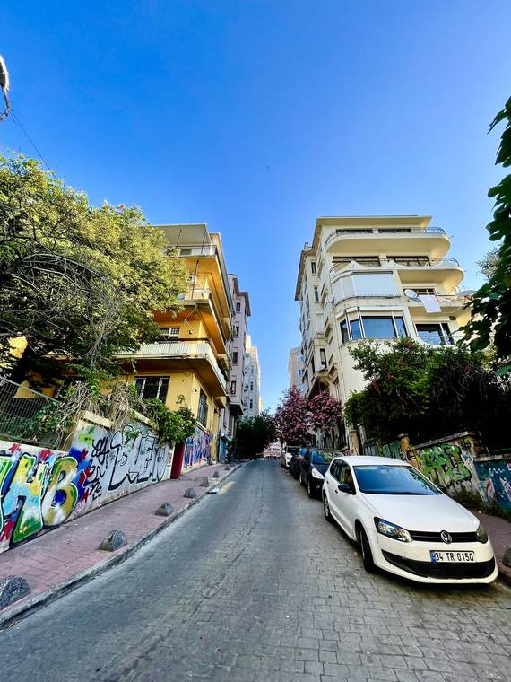A steep cobbled street lined with buildings and street art in Istanbul, Turkey
