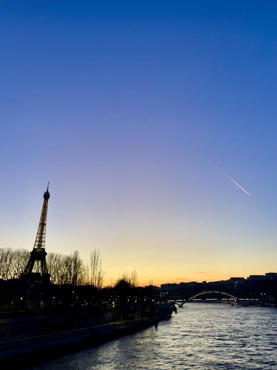 The Eiffel Tower at dusk over the Seine in Paris, France